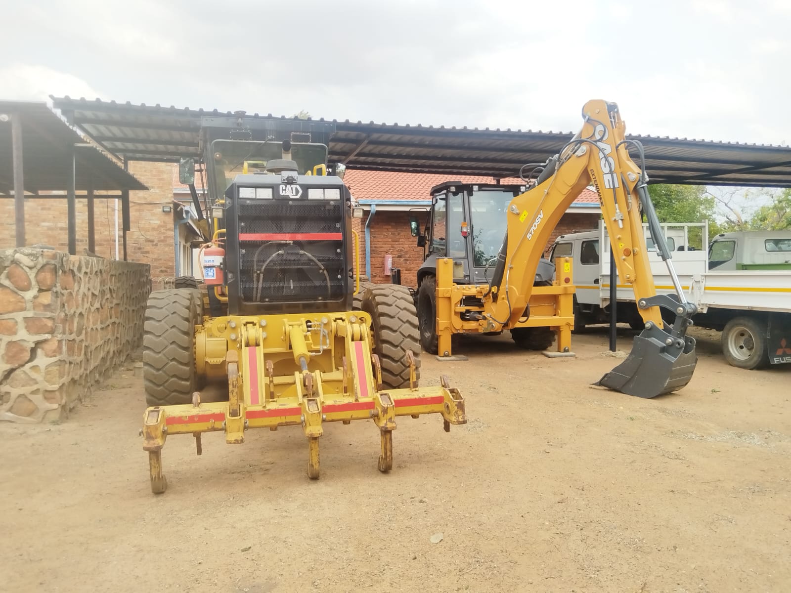Motor grader and backhoe loader in Loina yard